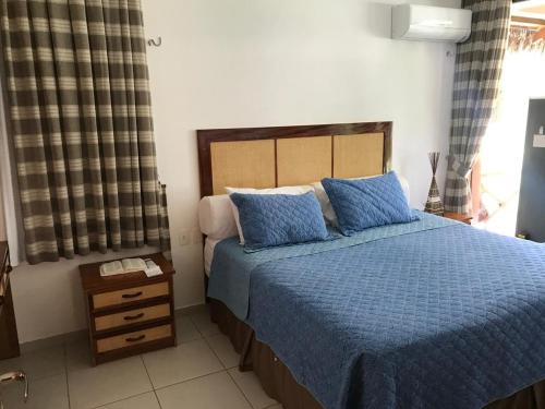 a bedroom with a blue bed with blue pillows at Fleixeiras Eco Residence in Trairi