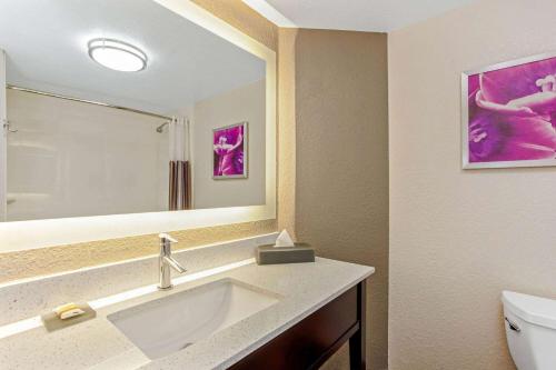 y baño con lavabo, espejo y aseo. en La Quinta Inn & Suites by Wyndham Panama City en Panamá