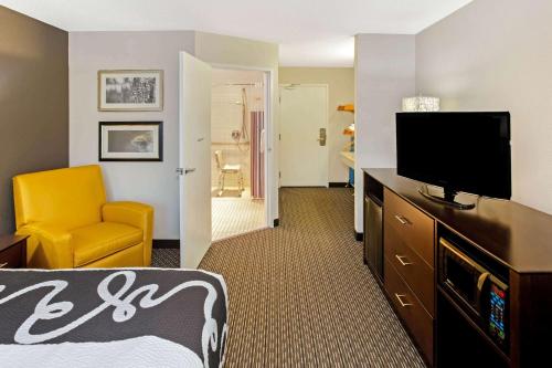 a hotel room with a bed and a flat screen tv at La Quinta by Wyndham Milwaukee Delafield in Delafield