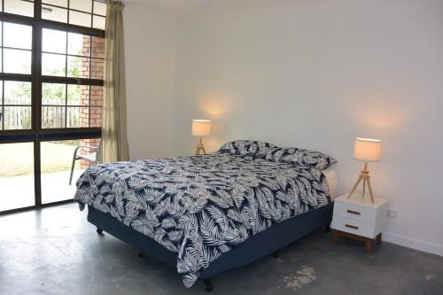 a bedroom with a bed with a black and white comforter at Alicante in Point Lookout