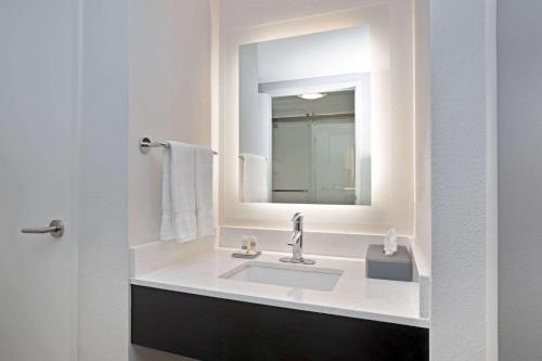 a bathroom with a sink and a mirror at La Quinta by Wyndham Rancho Cordova Sacramento in Rancho Cordova