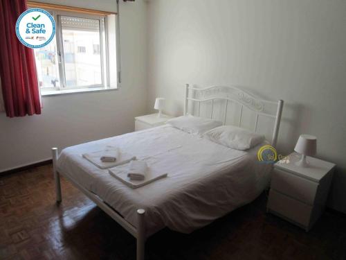ein Schlafzimmer mit einem weißen Bett und einem Fenster in der Unterkunft Sol e Praia - Peniche III in Peniche