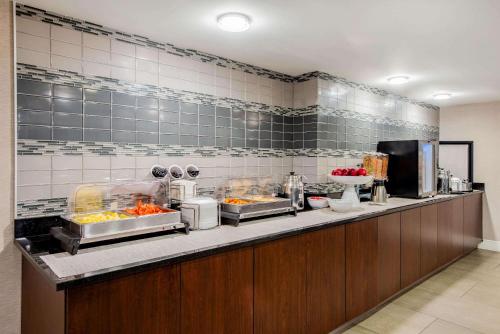 a restaurant kitchen with a buffet line with food at La Quinta by Wyndham Baltimore BWI Airport in Linthicum Heights
