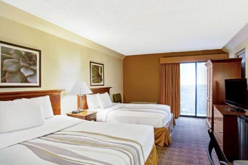 a hotel room with two beds and a television at La Quinta by Wyndham Stamford / New York City in Stamford