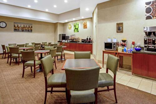 a restaurant with tables and chairs and a counter at La Quinta by Wyndham Stamford / New York City in Stamford