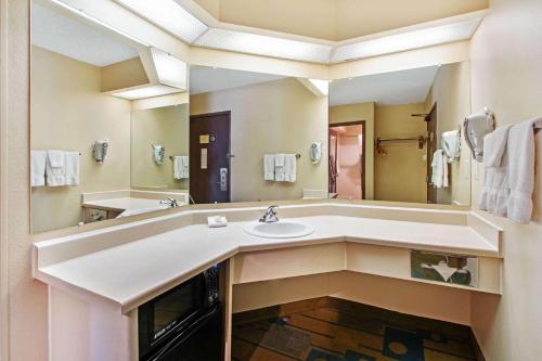 a bathroom with a sink and a large mirror at La Quinta by Wyndham Albuquerque Journal Ctr NW in Albuquerque