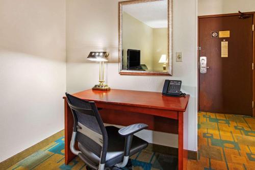 a desk with a chair and a lamp and a mirror at La Quinta by Wyndham Albuquerque Journal Ctr NW in Albuquerque