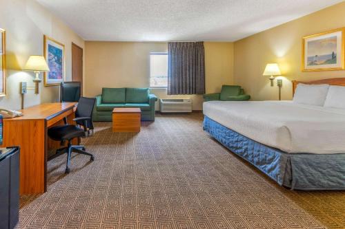 a hotel room with a bed and a desk and chairs at La Quinta Inn & Suites by Wyndham Las Cruces Organ Mountain in Las Cruces
