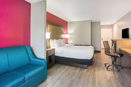 a hotel room with a bed and a couch at La Quinta by Wyndham Fort Smith in Massard