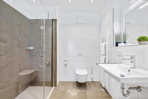 a bathroom with a shower and a sink and a toilet at Perlentaucher in Olpenitz