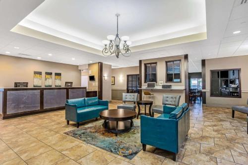 a lobby with blue chairs and a table at La Quinta by Wyndham Biloxi in Biloxi
