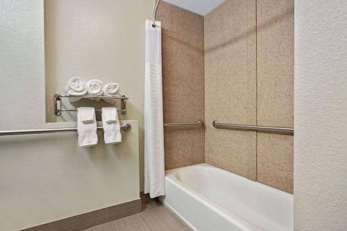 a bathroom with a tub and a toilet and towels at La Quinta by Wyndham Palestine in Palestine