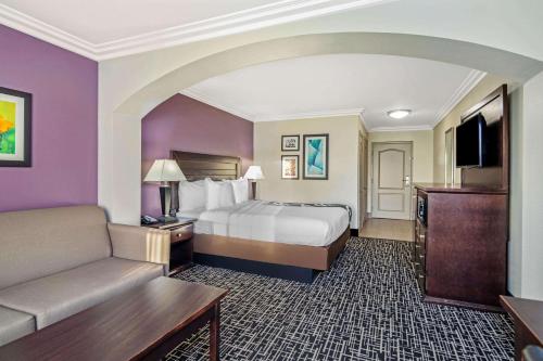a hotel room with a bed and a couch at La Quinta by Wyndham Temecula in Temecula