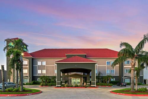 hotel z palmami na parkingu w obiekcie La Quinta by Wyndham Mercedes w mieście Mercedes