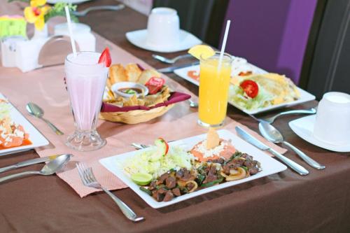 Una mesa con platos de comida y bebidas sobre ella. en Hotel Two Select, en Culiacán