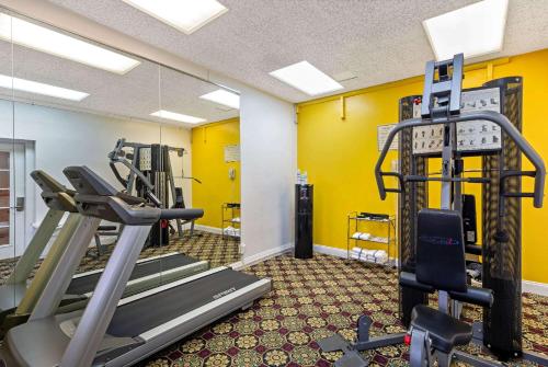 a gym with tread machines and yellow walls at University Inn & Suites Berkeley in Berkeley