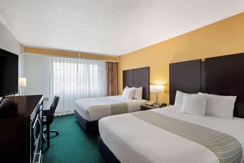 バークレーにあるラ キンタ イン バークレーのベッド2台、薄型テレビが備わるホテルルームです。
