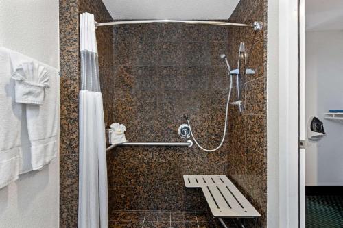 a bathroom with a shower with a bench in it at La Quinta Inn by Wyndham Berkeley in Berkeley