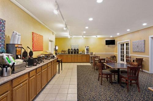 a restaurant with a counter and a table and chairs at University Inn & Suites Berkeley in Berkeley
