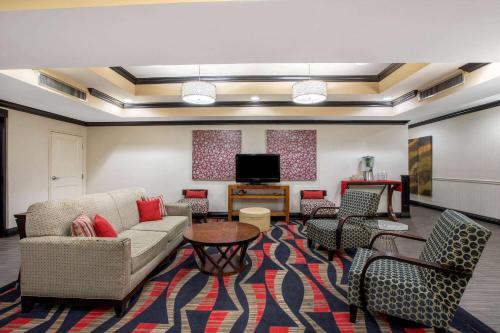 a living room with a couch and chairs and a tv at La Quinta by Wyndham Conway in Conway