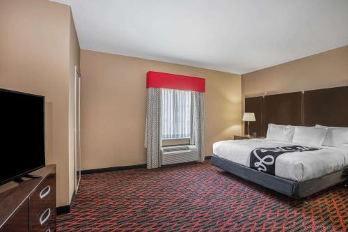 a hotel room with a bed and a flat screen tv at La Quinta by Wyndham Conway in Conway