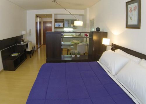 um quarto com uma grande cama roxa e uma sala de estar em Concord Callao by Recoleta Apartments em Buenos Aires