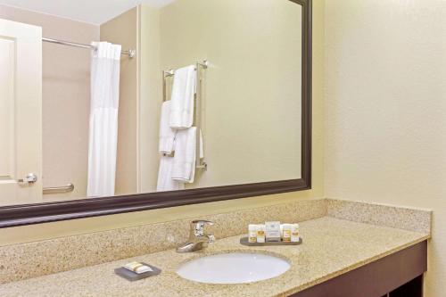 a bathroom with a sink and a large mirror at La Quinta by Wyndham Lancaster in Ronks