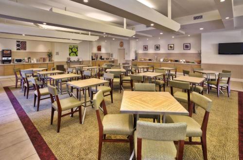 a dining room with tables and chairs and a cafeteria at La Quinta by Wyndham Danbury in Danbury