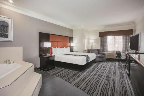 a hotel room with a bed and a bathroom at La Quinta by Wyndham Dublin - Pleasanton in Dublin