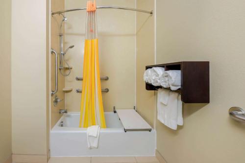 a bathroom with a shower with a yellow shower curtain at La Quinta by Wyndham Marshall in Marshall