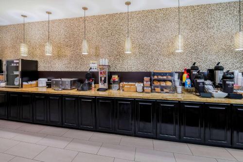 a kitchen with black cabinets and a counter with food at La Quinta by Wyndham Marshall in Marshall