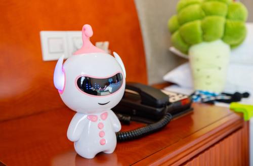 a toy animal on a desk with a phone at Jinhai New Century Grand Hotel Ninghai in Ninghai
