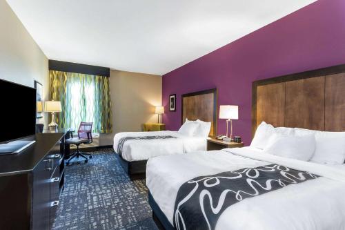 Habitación de hotel con 2 camas y pared púrpura en La Quinta by Wyndham Monahans en Monahans