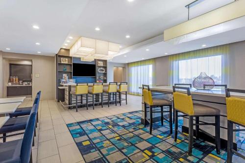 a dining room and kitchen with yellow chairs and tables at La Quinta by Wyndham Odessa North - Sienna Tower in Odessa