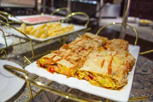 a plate of food on a table with french fries at Dostar Hotel in Aktau