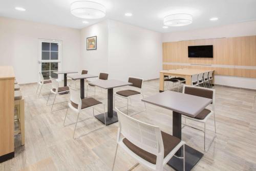 a room with tables and chairs and a flat screen tv at Microtel Inn & Suites by Wyndham Cuauhtemoc Campos Menonitas in Cuauhtémoc