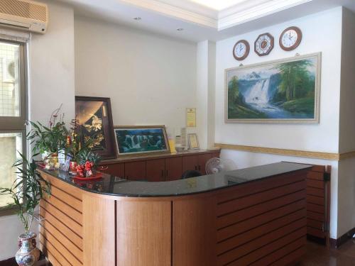 Huaxin Hotel في جينتشينغ: غرفة كبيرة مع مكتب وساعات على الحائط