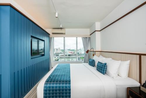 a hotel room with a bed and a window at Hotel Amber Sukhumvit 85 in Bangkok