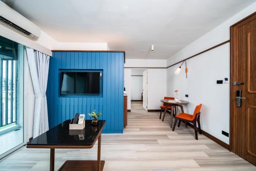 a room with a blue wall and a table at Hotel Amber Sukhumvit 85 in Bangkok