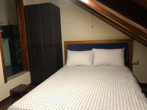 a bed with a wooden headboard in a bedroom at Mini Departamento Cómodo in Cuenca