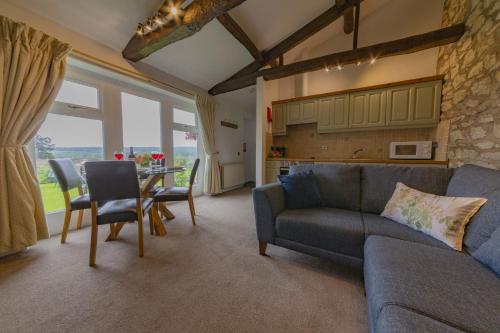 een woonkamer met een bank en een tafel met stoelen bij Ryedale Cottage in Helmsley
