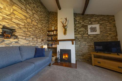 a living room with a blue couch and a fireplace at Ryedale Cottage in Helmsley