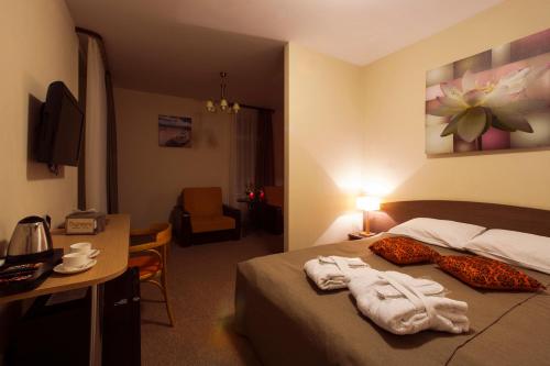 a hotel room with a bed with towels on it at Dzintars Hotel in Jūrmala