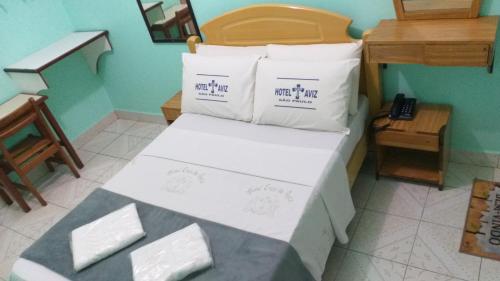 a bed with white sheets and pillows in a room at Hotel Cruz de Aviz in Sao Paulo