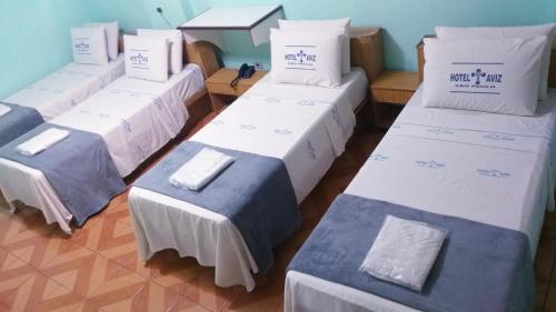 a group of four beds in a room at Hotel Cruz de Aviz in Sao Paulo