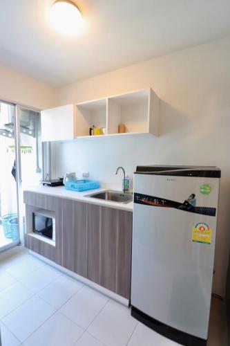 a kitchen with a refrigerator and a sink at D Condo Sign Chiang Mai R628 in Chiang Mai