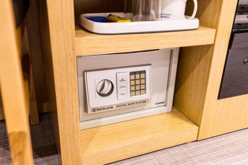 un four micro-ondes dans une étagère en bois dans la cuisine dans l'établissement Symphony Hotel, à Suwon
