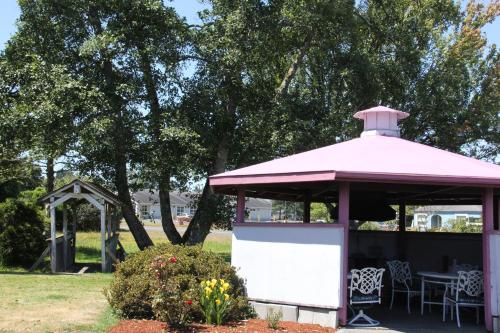 a pink pavilion with a table and chairs in a park at Mariners Cove Inn in Westport