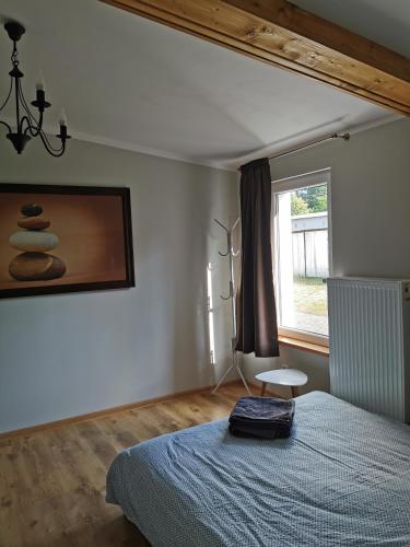 - une chambre avec un lit, une fenêtre et une chaise dans l'établissement Pensjonat Dwa Dęby, à Hajnówka
