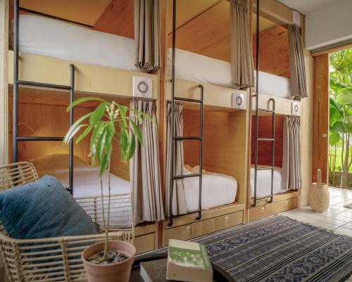 チャングーにあるKultur Umalas - CHSE Certifiedの二段ベッド2台とテーブルが備わる客室です。
